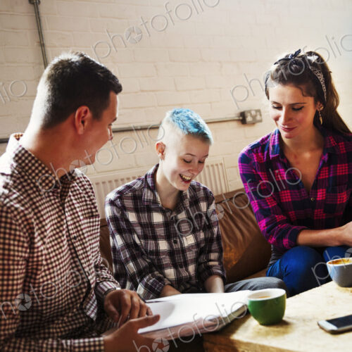 Specialist coffee shop. Three people, two adults and a young person seated on a sofa. Specialist coffee shop. Three people, two adults and a young person seated on a sofa.