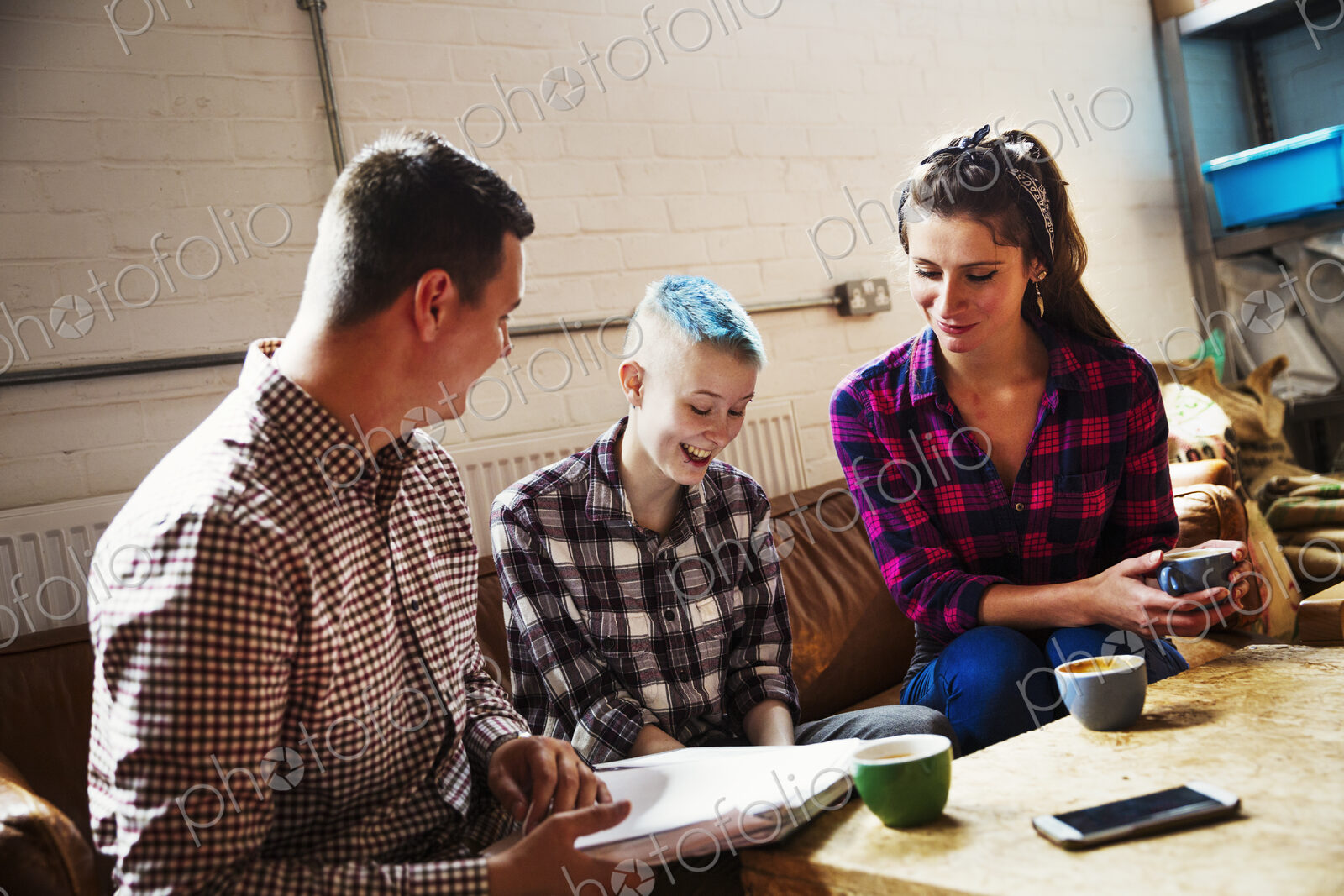 Specialist coffee shop. Three people, two adults and a young person seated on a sofa.