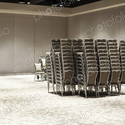 Stacked chairs in an empty convention center meeting room. Stacked chairs in an empty convention center meeting room.