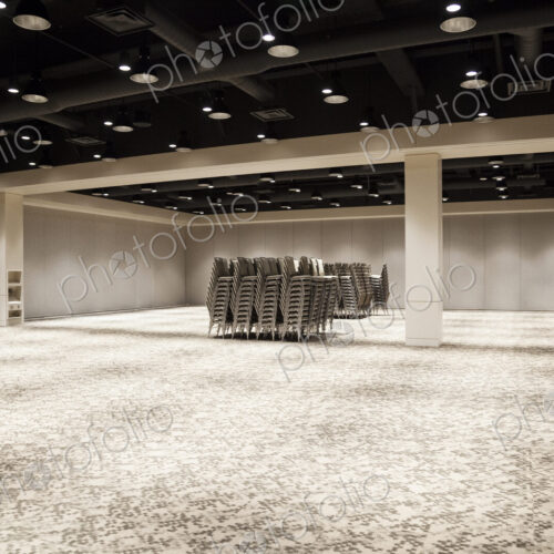 Stacked chairs in an empty convention center meeting room. Stacked chairs in an empty convention center meeting room.