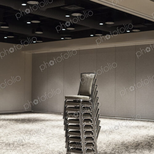 Stacked chairs in an empty convention center meeting room. Stacked chairs in an empty convention center meeting room.