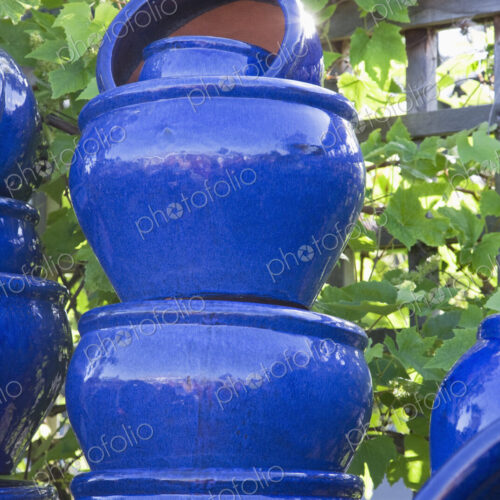 Stacked painted blue pots in garden centre.
