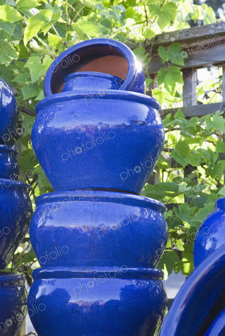 Stacked painted blue pots in garden centre.