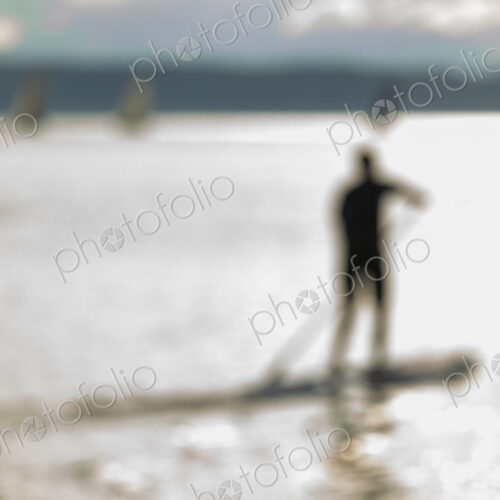 Stand up paddler on the water, blurred motion.
