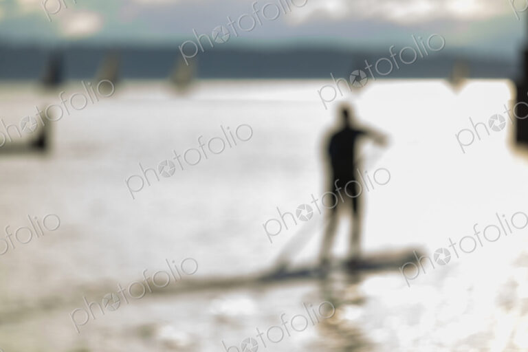 Stand up paddler on the water, blurred motion.