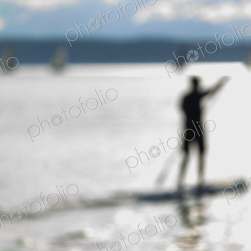 Stand up paddler on the water, blurred motion.