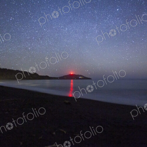 Star filled sky above Freshwater Bay, Port Angeles, the orange sun on the horizon.