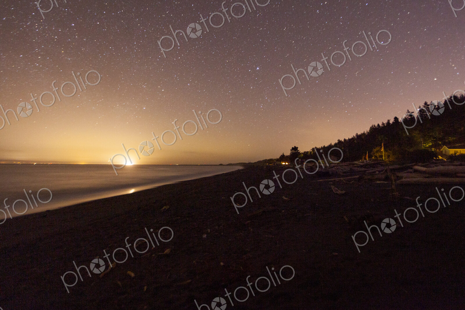 Star filled sky and the sun emerging on the horizon above Freshwater Bay, Port Angeles