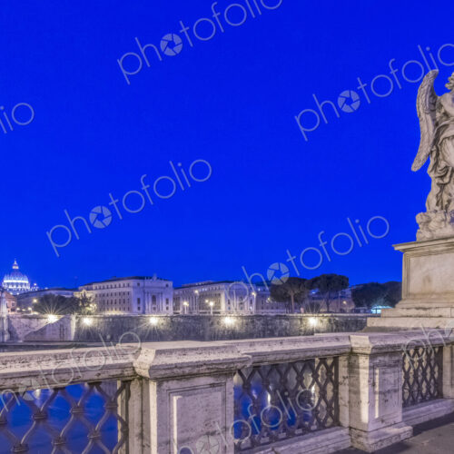 Statue over illuminated bridge at night, Rome, Italy