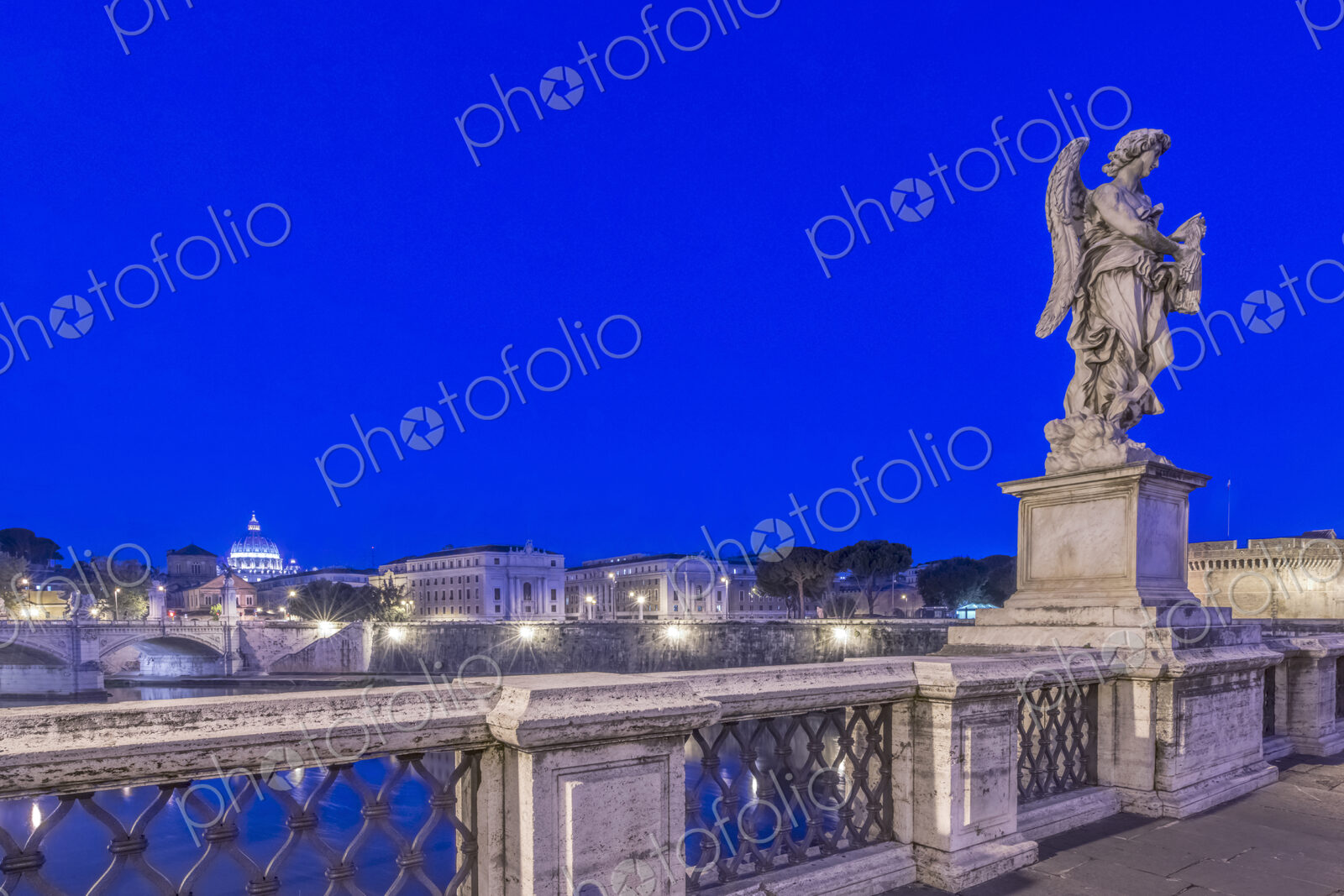 Statue over illuminated bridge at night, Rome, Italy