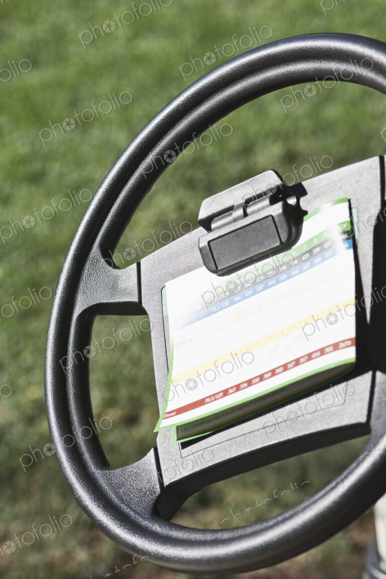 Steering wheel for golf buggy with score card clipped on.