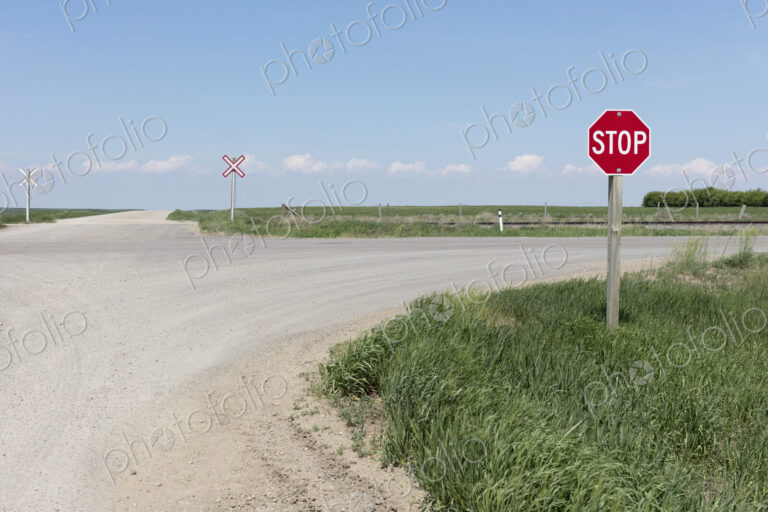 Stop sign and railroad crossing along rural road,