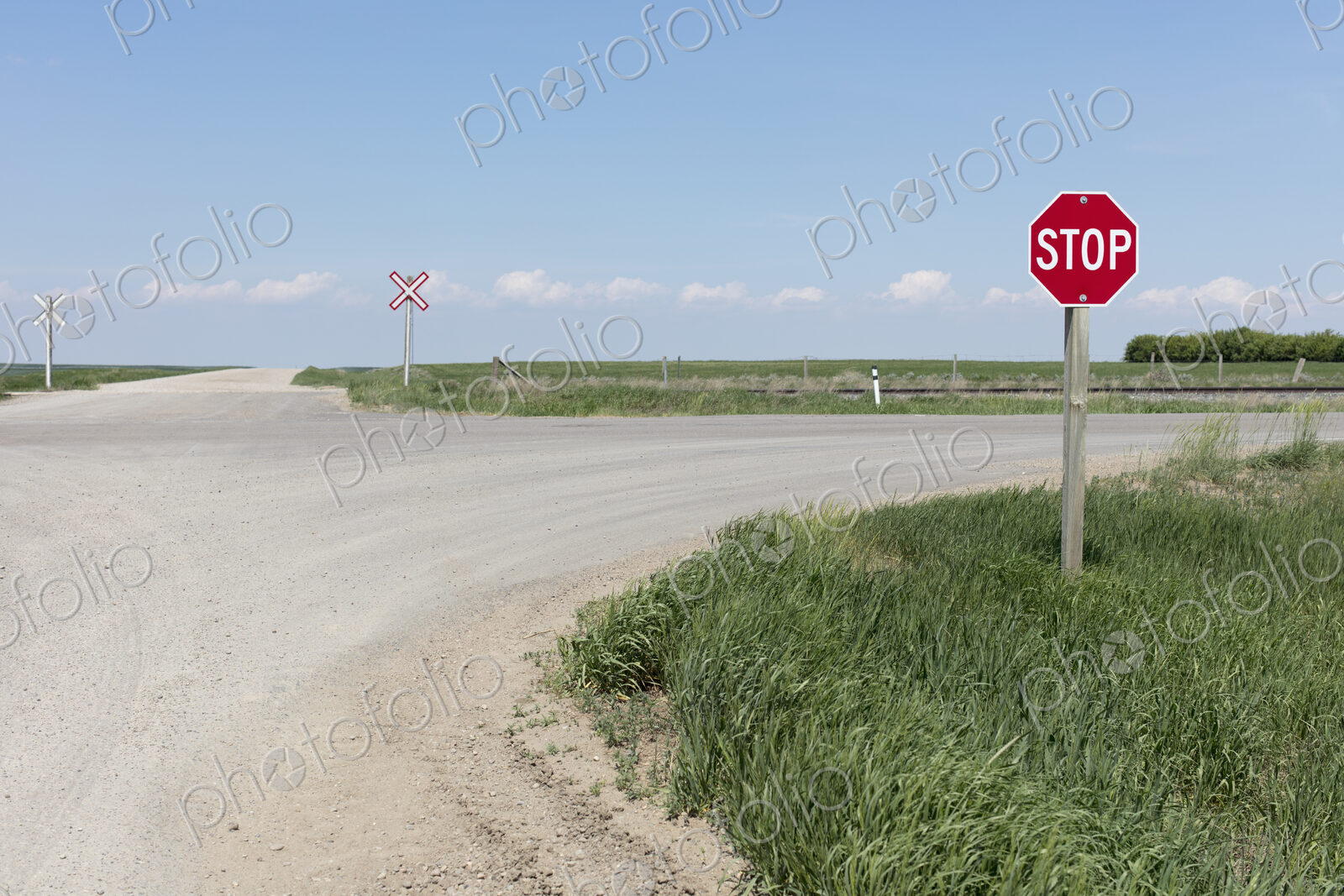 Stop sign and railroad crossing along rural road,