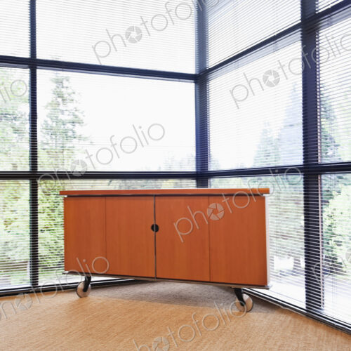 Storage cabinet in a corner office with floor to ceiling glass walls. Storage cabinet in a corner office with floor to ceiling glass walls.