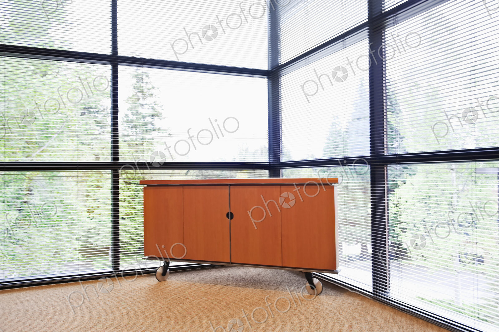 Storage cabinet in a corner office with floor to ceiling glass walls.