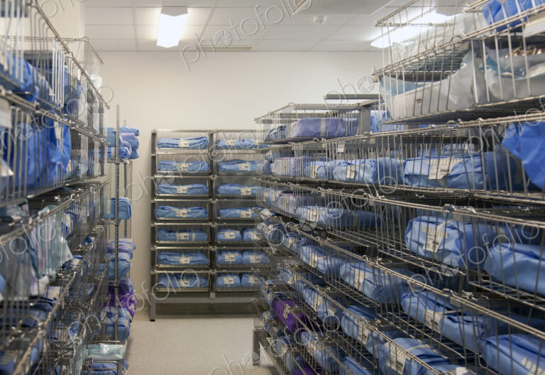 Storage room in a modern hospital, rows of sterile equipment packs in blue fabric.