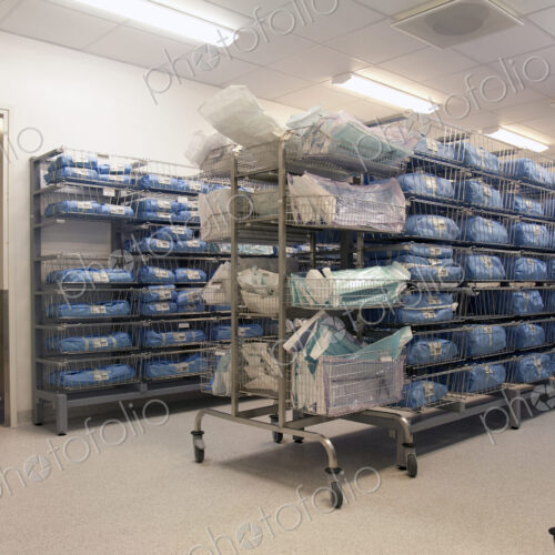 Storage room in a modern hospital, rows of sterile equipment packs in blue fabric.