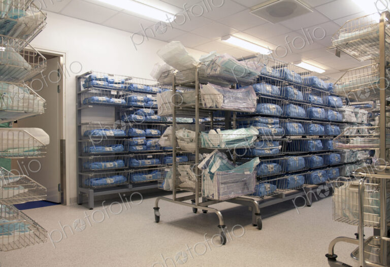 Storage room in a modern hospital, rows of sterile equipment packs in blue fabric.