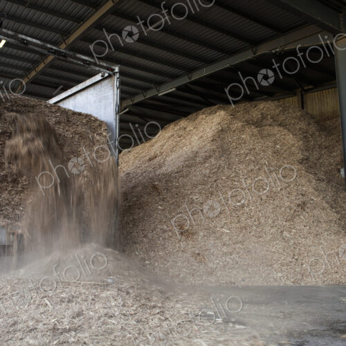 Stored organic waste being poured from a lorry into a large warehouse for biomass fuel…