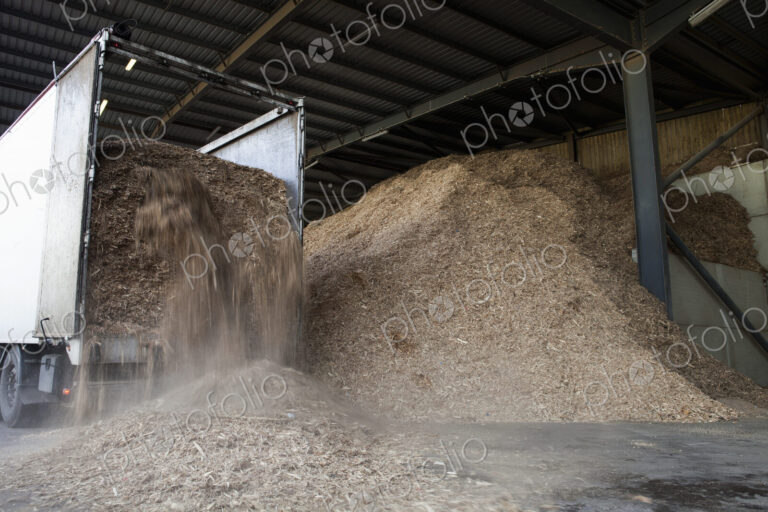Stored organic waste being poured from a lorry into a large warehouse for biomass fuel…