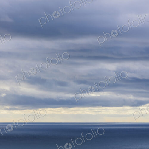 Storm clouds clearing over expansive ocean, dappled sunlight on water, northern Oregon…