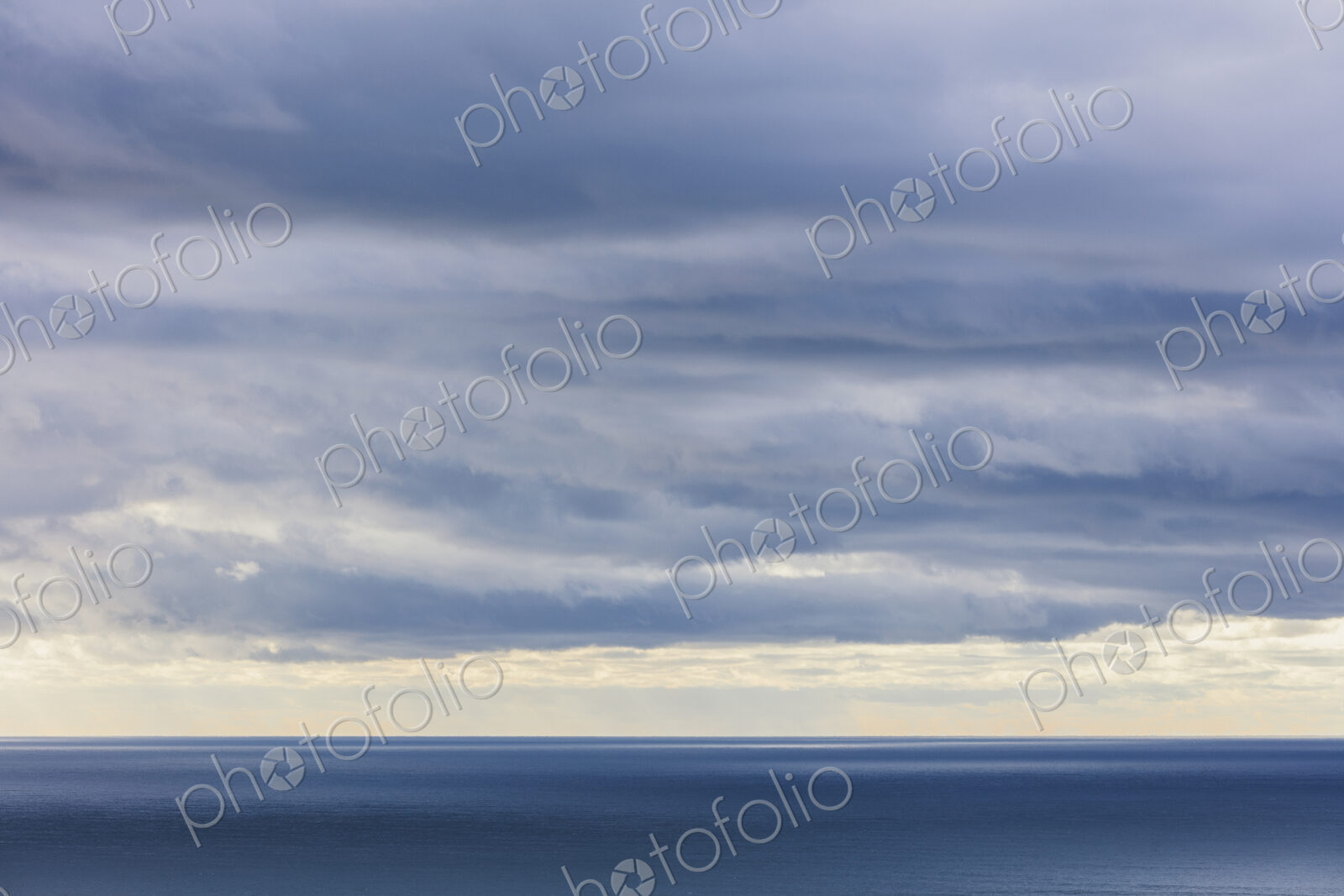 Storm clouds clearing over expansive ocean, dappled sunlight on water, northern Oregon…
