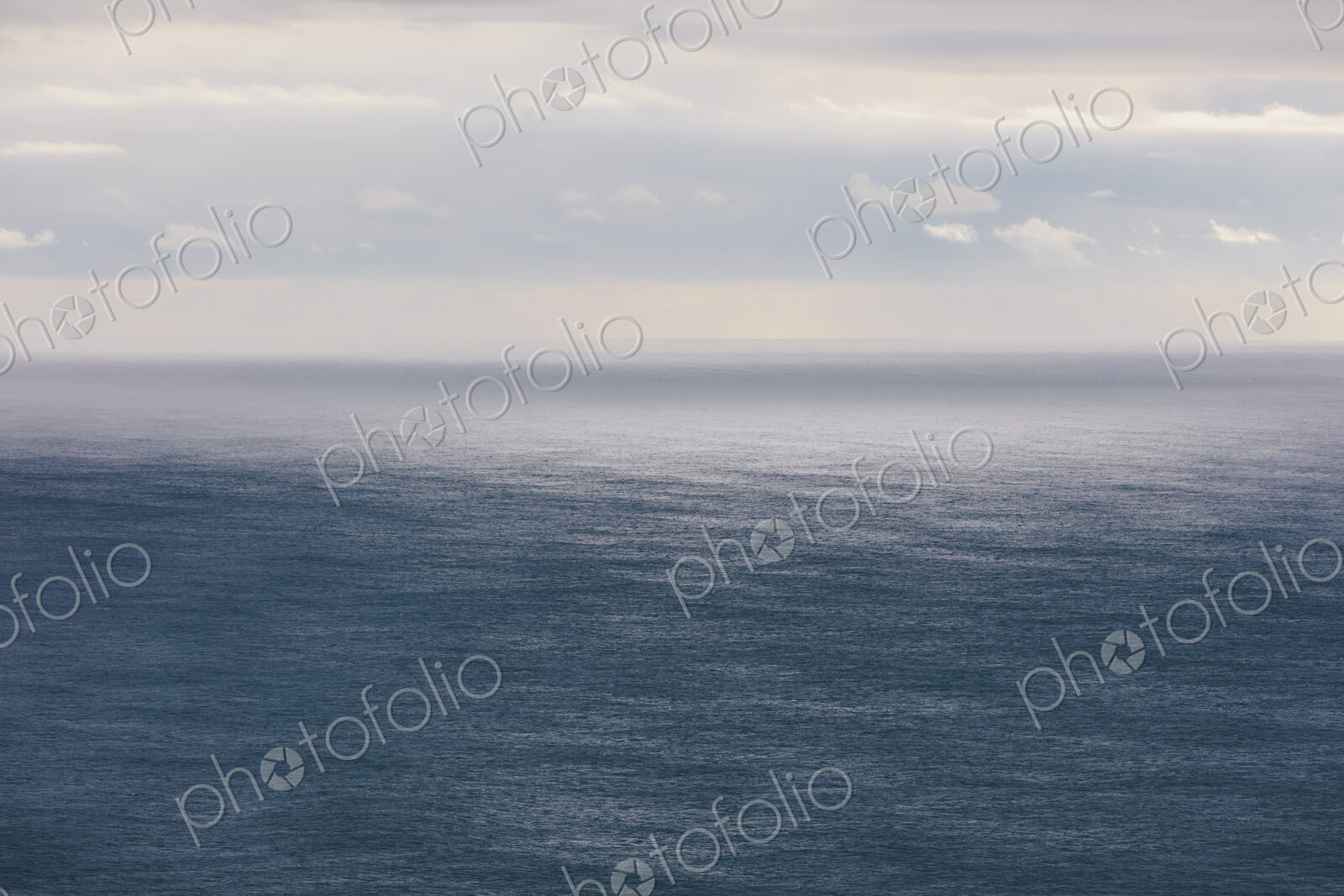 Storm clouds clearing over expansive ocean, dappled sunlight on water, northern Oregon…