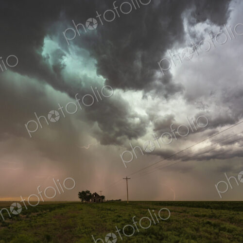 Storm clouds gathering over a small house on the horizon in a flat landscape. Storm clouds gathering over a small house on the horizon in a flat landscape.