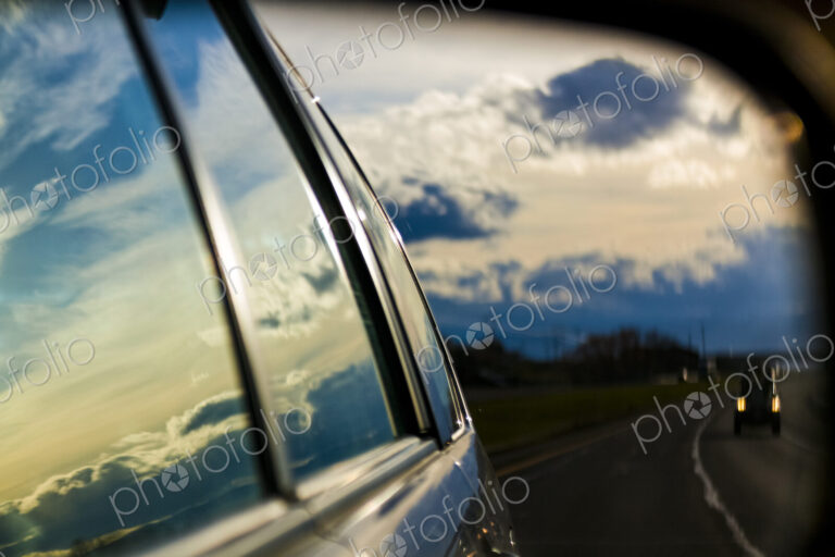 Storm clouds reflection on car windows and side mirror