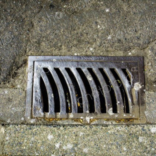 Storm drain on a roadway, a metal grille. Storm drain on a roadway, a metal grille.