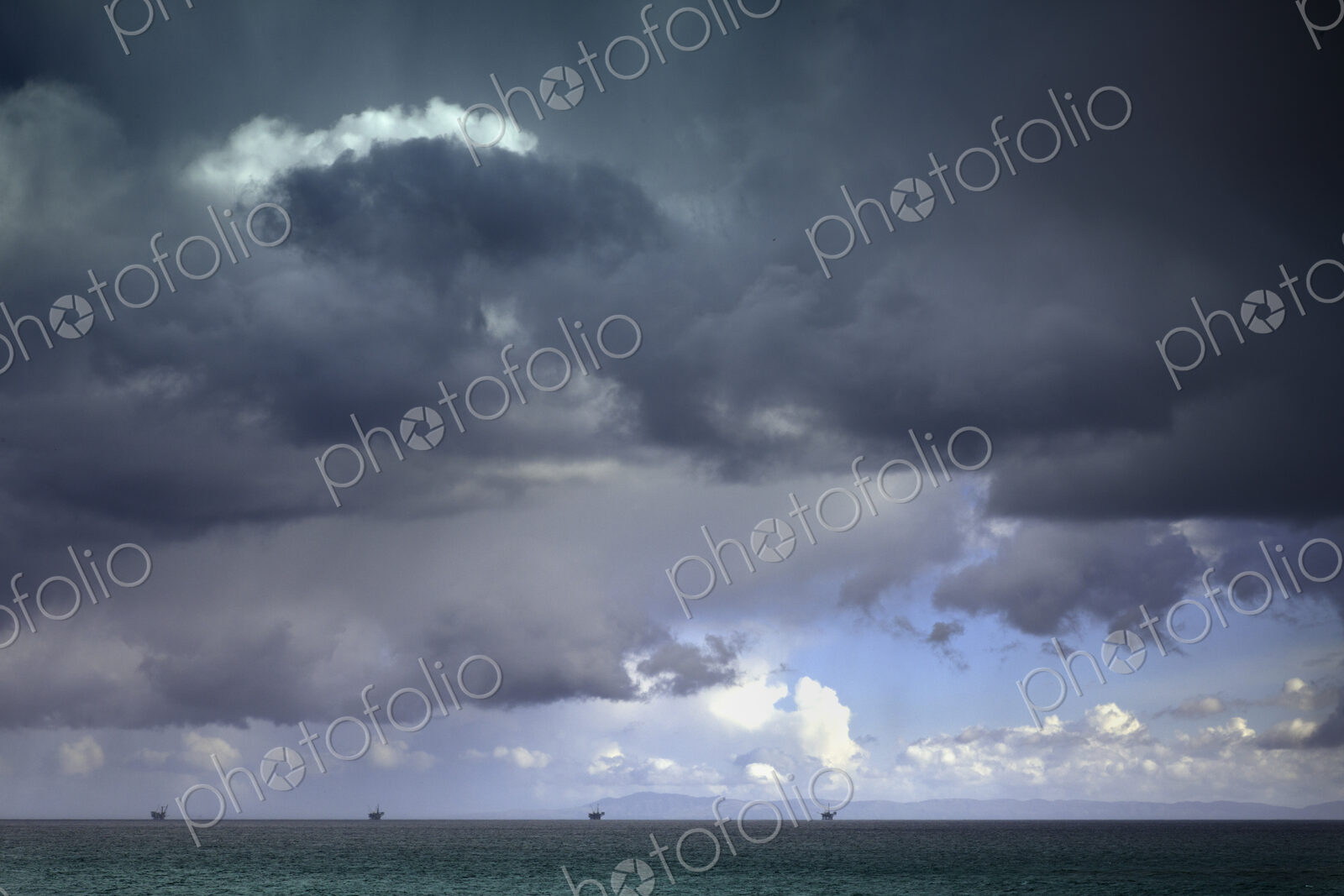Stormy sky over oil drilling platforms in ocean
