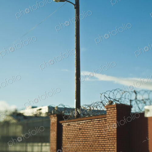 Street Lamp Behind Brick Wall With Concertina Wire Street Lamp Behind Brick Wall With Concertina Wire