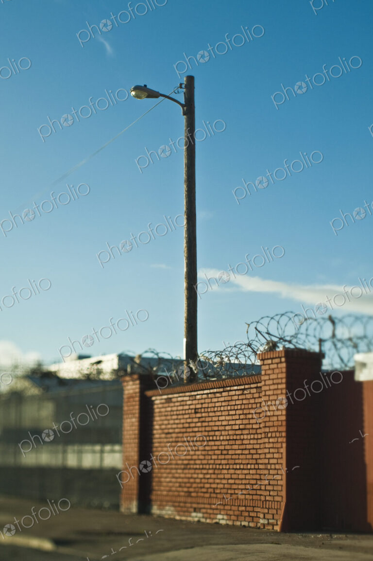 Street Lamp Behind Brick Wall With Concertina Wire