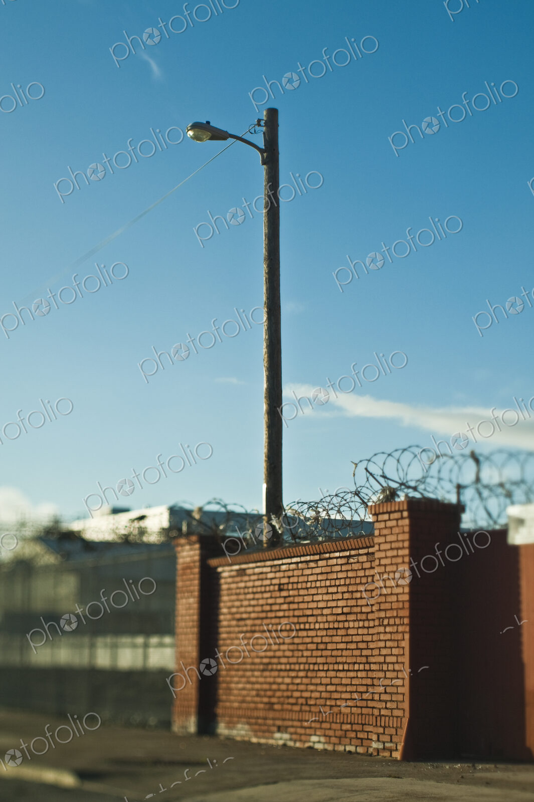 Street Lamp Behind Brick Wall With Concertina Wire