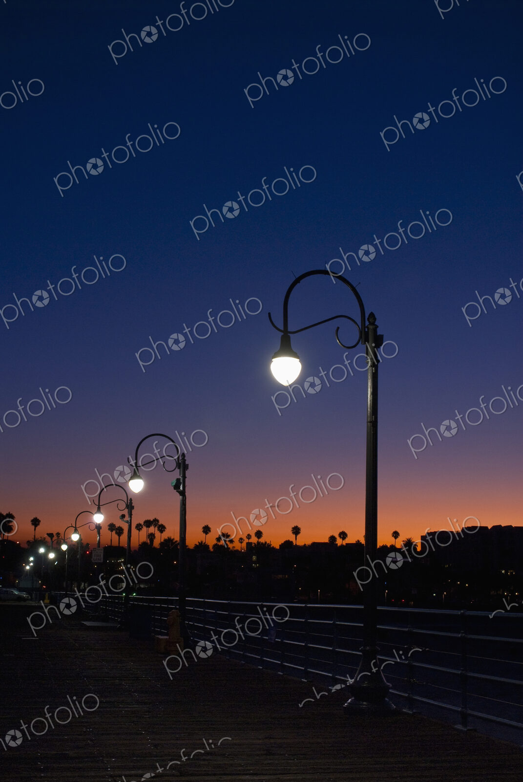 Streetlight with palm trees at sunset.