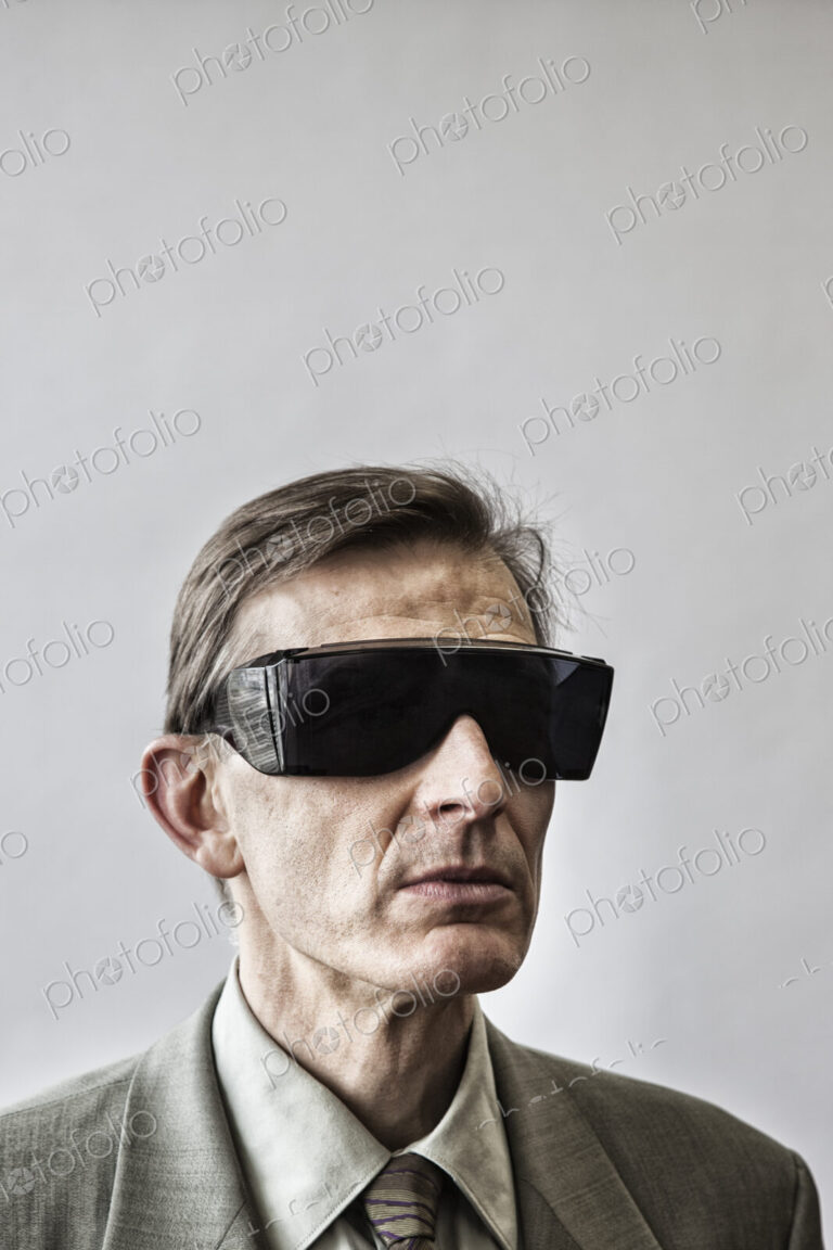 Studio portrait of caucasian man actor wearing large sunglasses or protective…