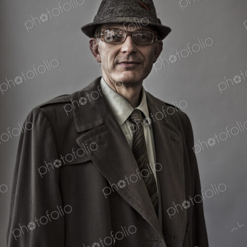 Studio portrait of caucasian man actor with a hat and overcoat on. Studio portrait of caucasian man actor with a hat and overcoat on.