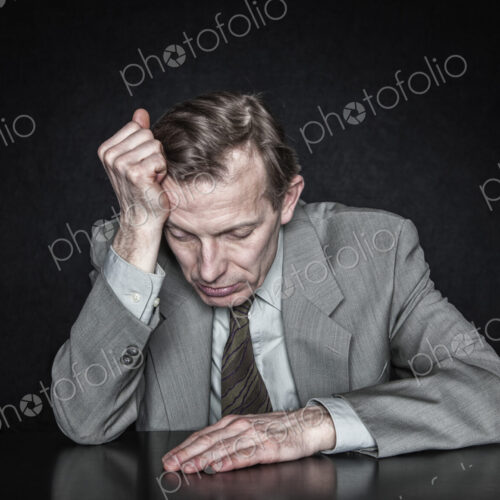 Studio portrait of caucasian man actor with his hand on his head looking down. Studio portrait of caucasian man actor with his hand on his head looking down.