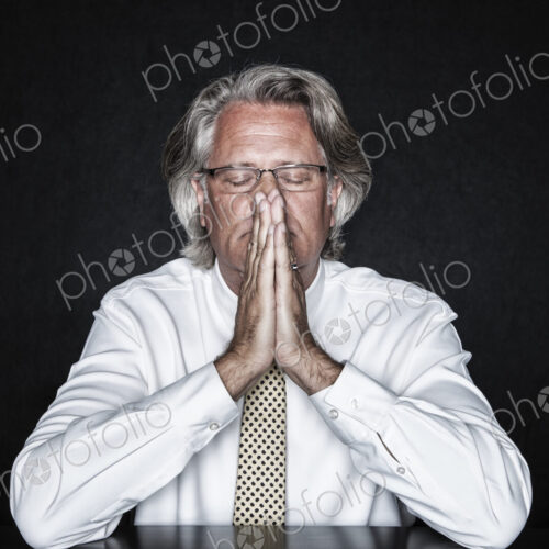 Studio portrait of caucasian man actor with his hands steepled, palms pressed together… Studio portrait of caucasian man actor with his hands steepled, palms pressed together…