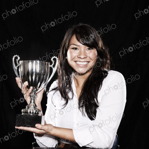 Studio portraits of an Asian woman holding a trophy. Studio portraits of an Asian woman holding a trophy.