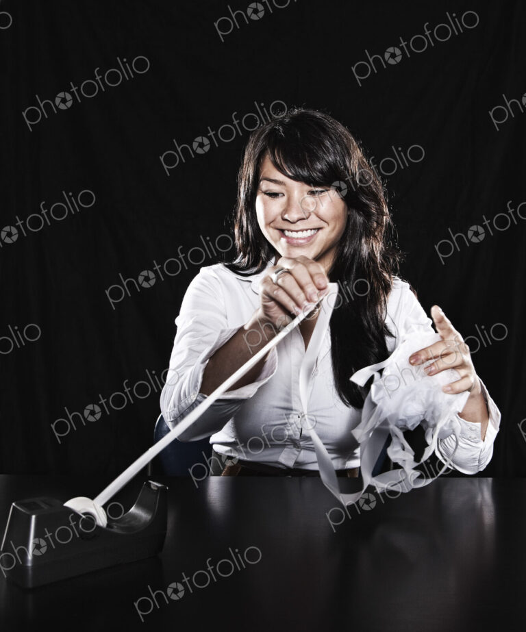 Studio portraits of an Asian woman with sticky tape tangled in her fingers.