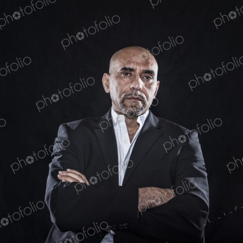 Studio portraits of hispanic man holding props.