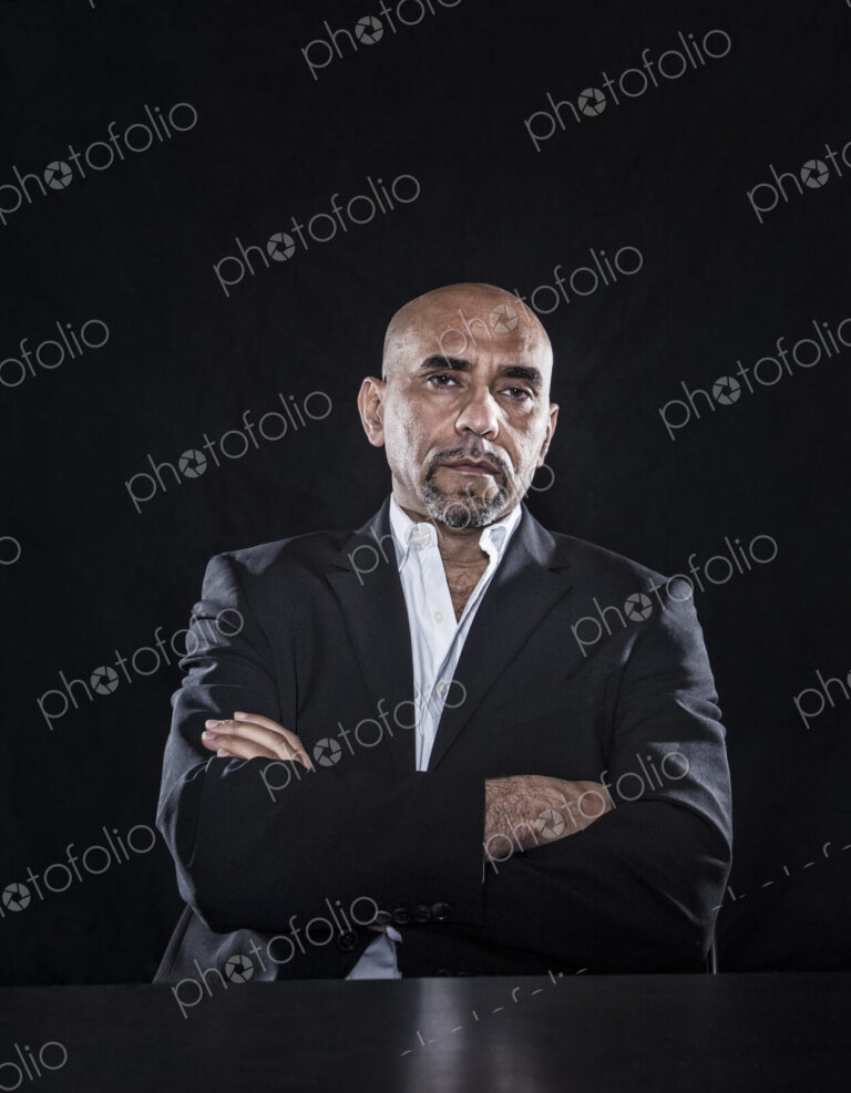 Studio portraits of hispanic man holding props.