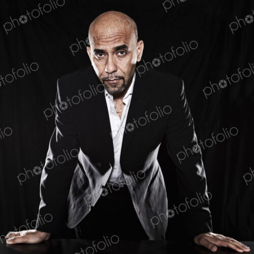 Studio portraits of hispanic man holding props.