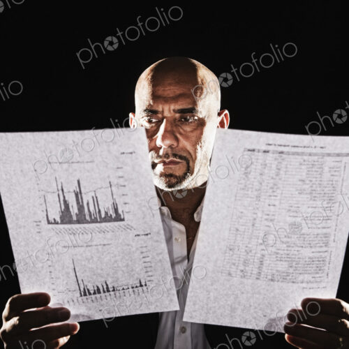 Studio portraits of hispanic man holding props.