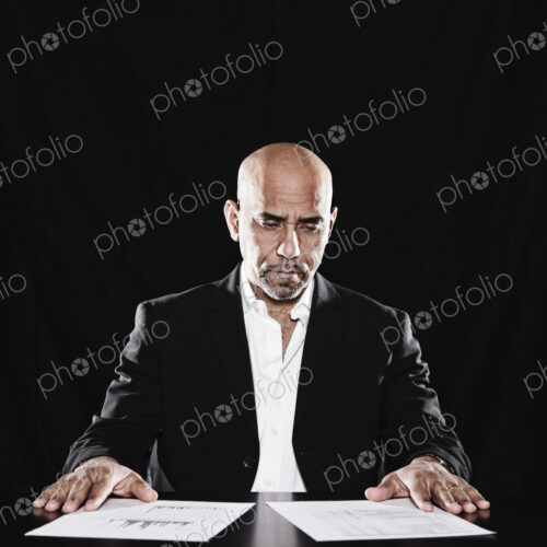 Studio portraits of hispanic man holding props.