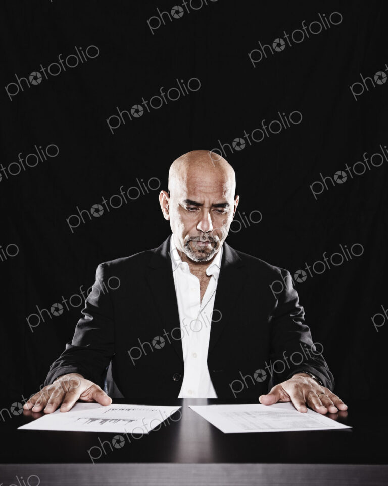 Studio portraits of hispanic man holding props.