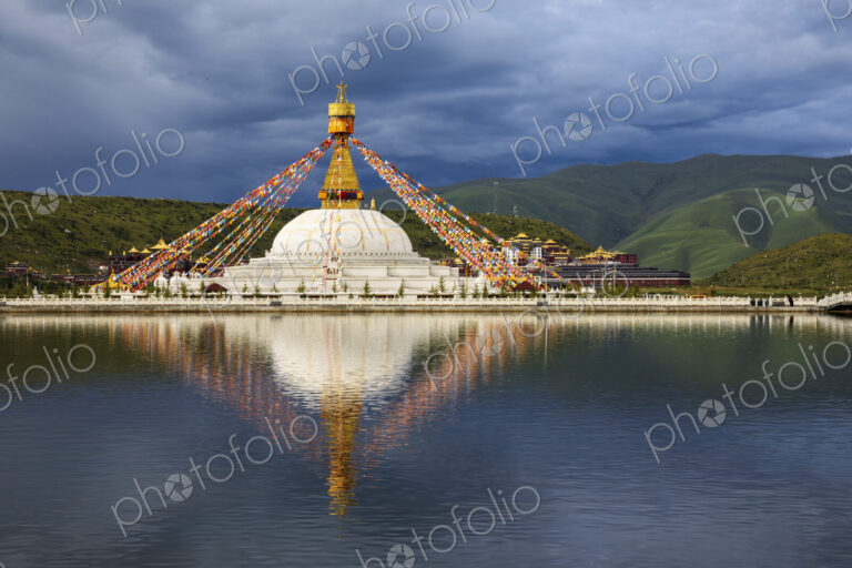 Stupa at the Zhuqing Wujian Zen Forest Monastery, decorated with prayer flags,…