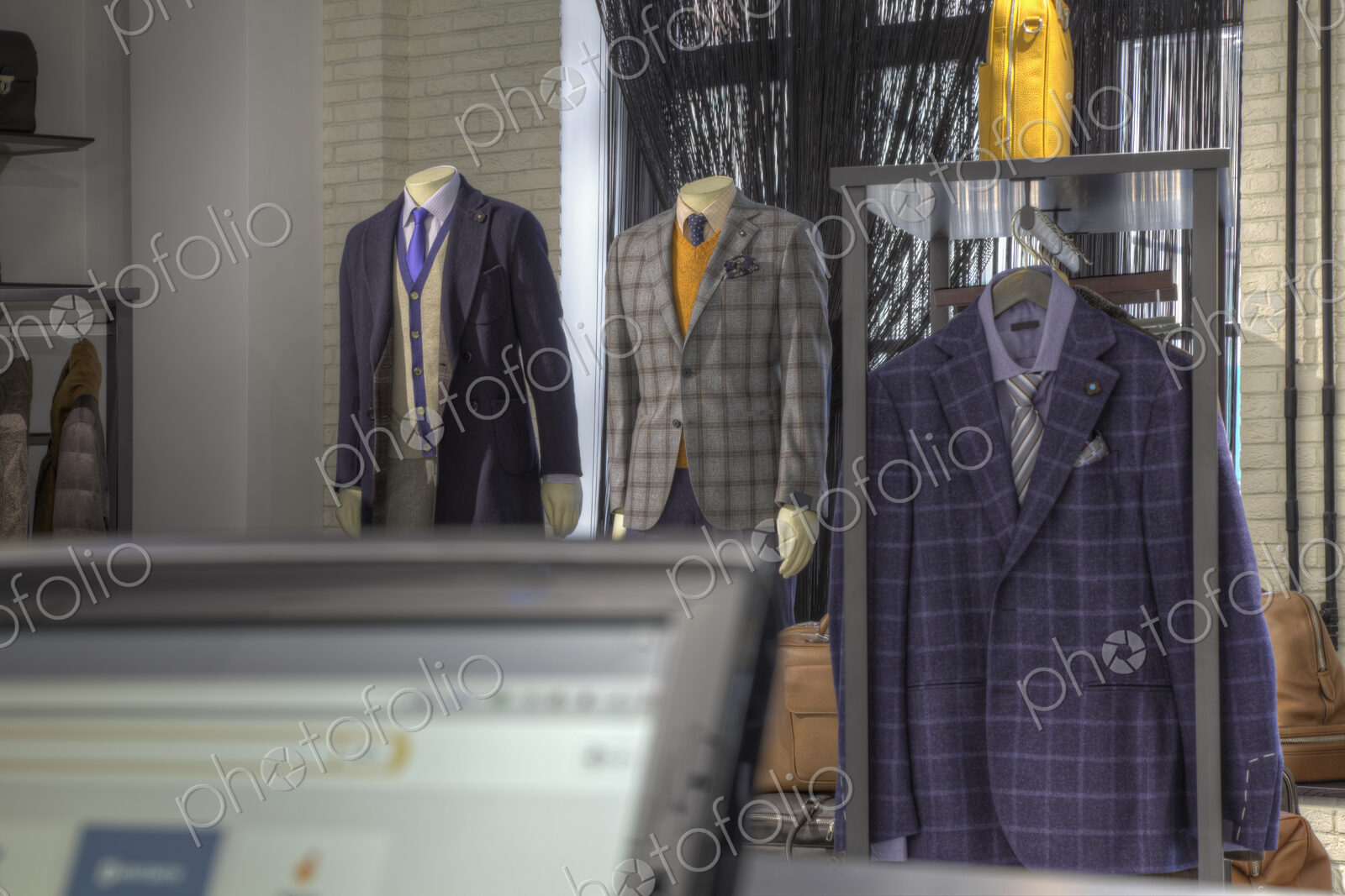 Suits and shoes near cash register in clothing store