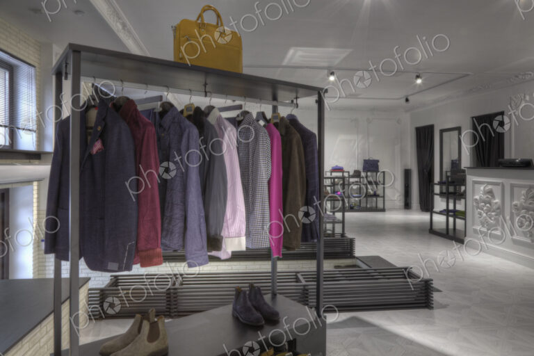 Suits and shoes on rack in clothing store for men